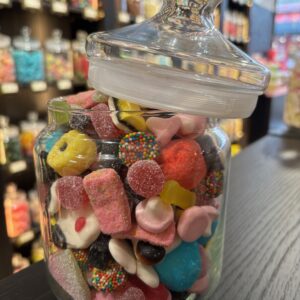 Jolie bonbonnière en verre pleine de bonbons colorés divers et variés.